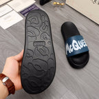 Black slide sandal outsole with textured tread pattern, side view