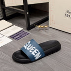 Black slide sandals with blue upper and white graffiti-style logo