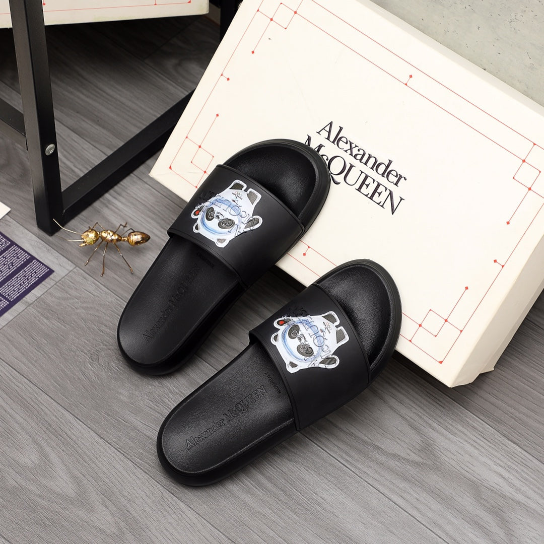 Black slide sandals with panda emblem on front strap