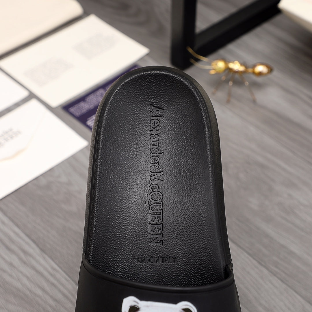 Black slide sandal with textured footbed and embossed logo text
