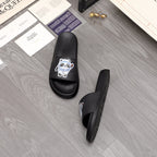 Black slide sandals with panda logo patch on front straps