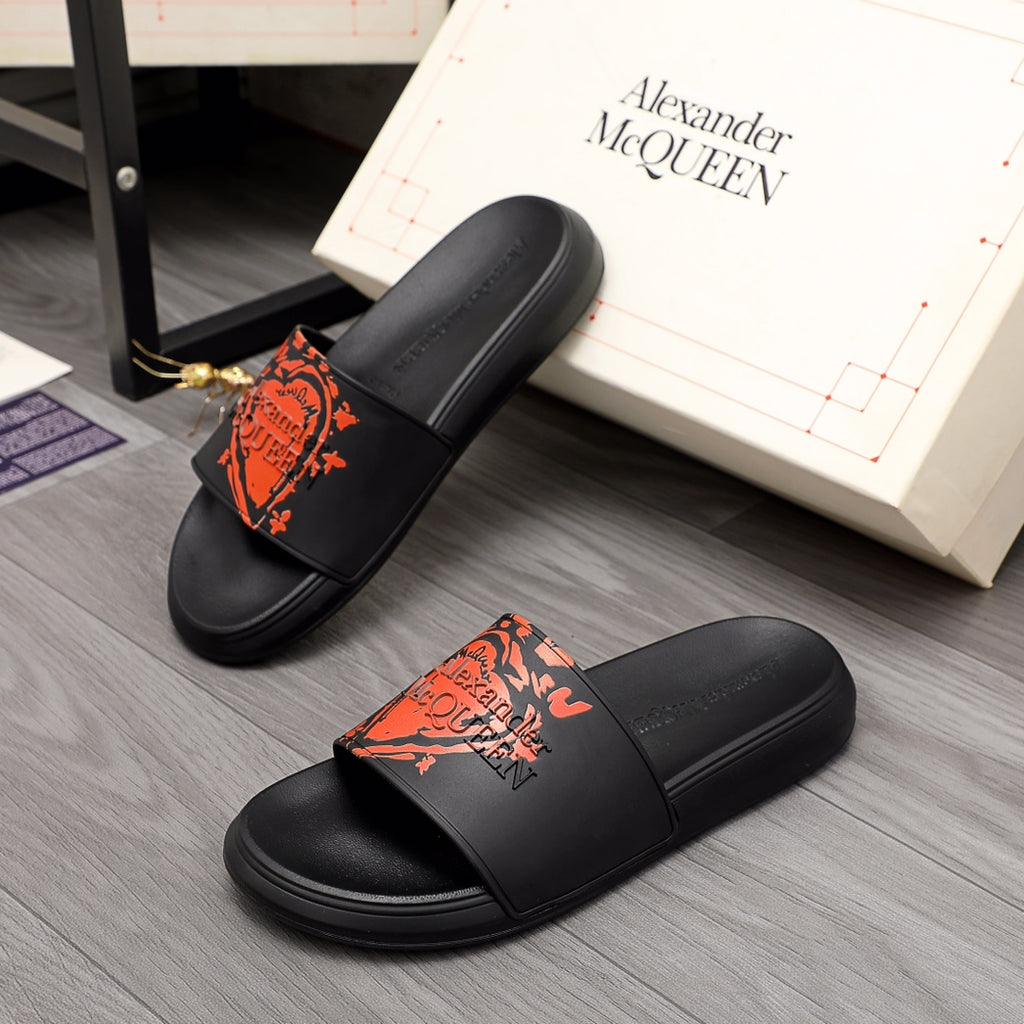 Black Alexander McQueen slide sandal with orange graphic logo on strap