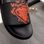 Black slide sandal strap with orange graphic logo detail