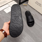 Black rubber slide sandal outsole with textured pattern, rear view