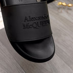 Close-up of black slide sandal strap with embossed Alexander McQUEEN logo