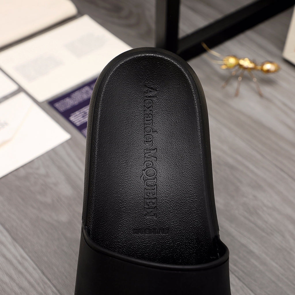 Close-up of black slide sandal footbed with embossed Alexander McQUEEN branding