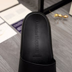 Close-up of black slide sandal footbed with embossed Alexander McQUEEN branding