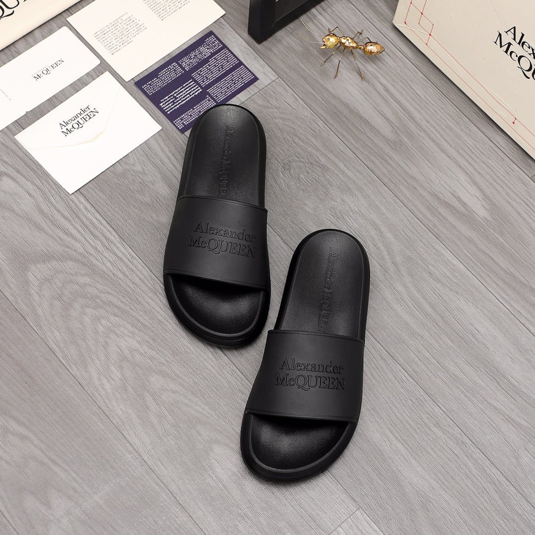 Pair of black slide sandals with wide strap and embossed Alexander McQUEEN logo