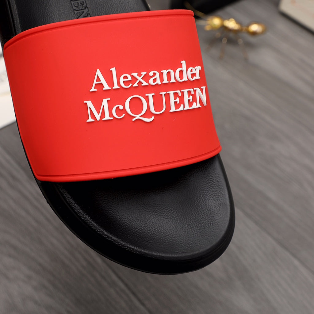 Close-up of black slide sandal with red Alexander McQUEEN logo strap