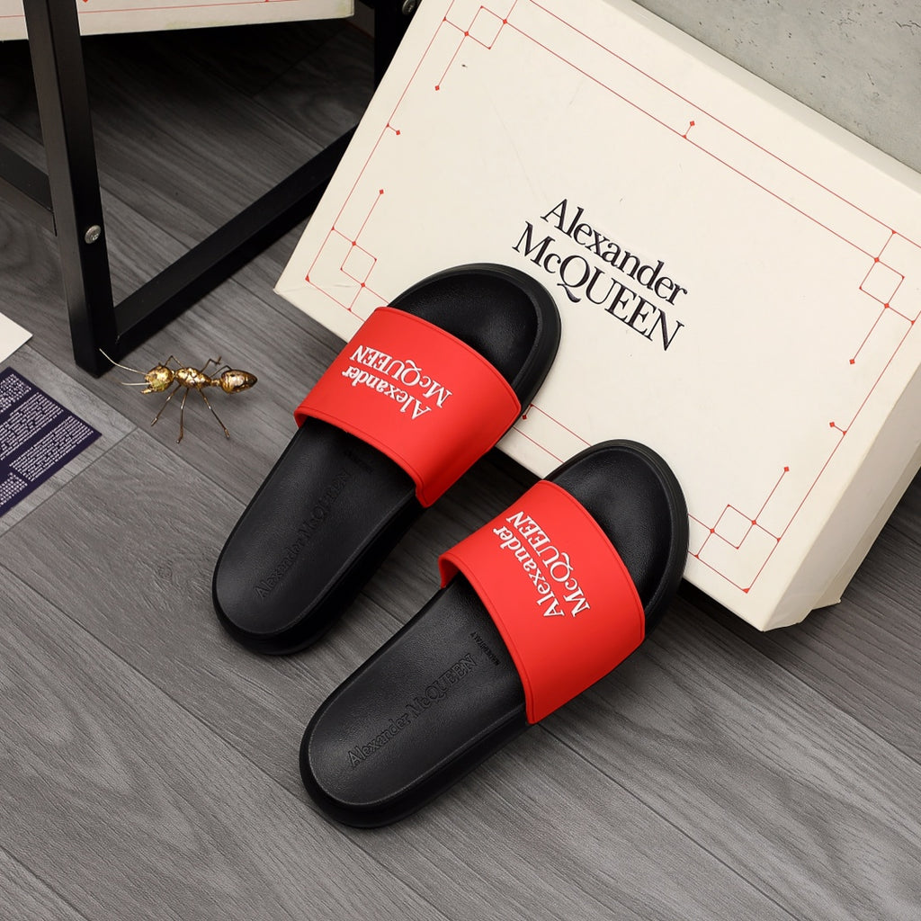 Black slide sandals with red Alexander McQUEEN logo bands, paired view