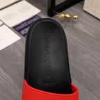 Black slide sandal footbed with embossed Alexander McQUEEN text and red trim