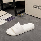 White slide sandals with wide front strap and embossed logo