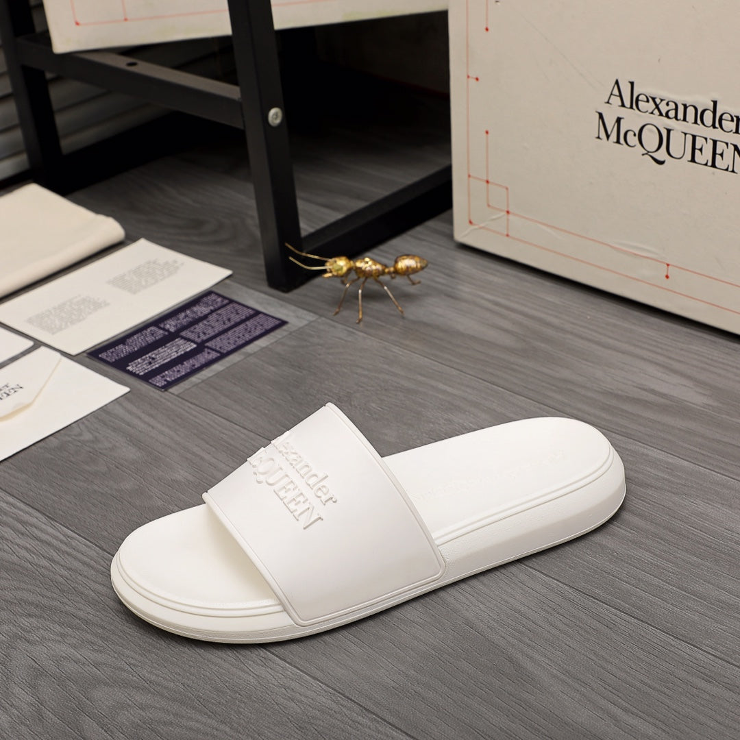 White slide sandals with wide front strap and embossed logo