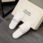 White slide sandals with wide front strap and embossed logo detail