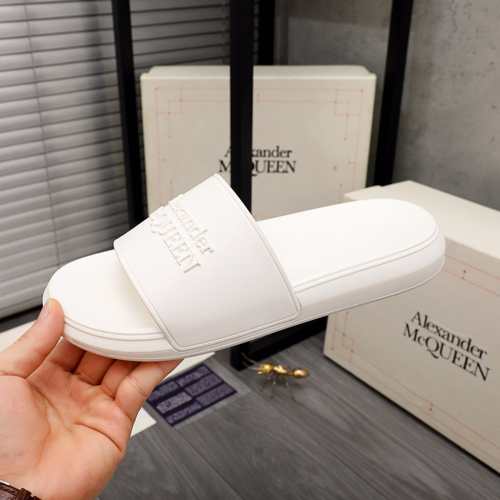White slide sandals with wide strap and embossed logo on foot