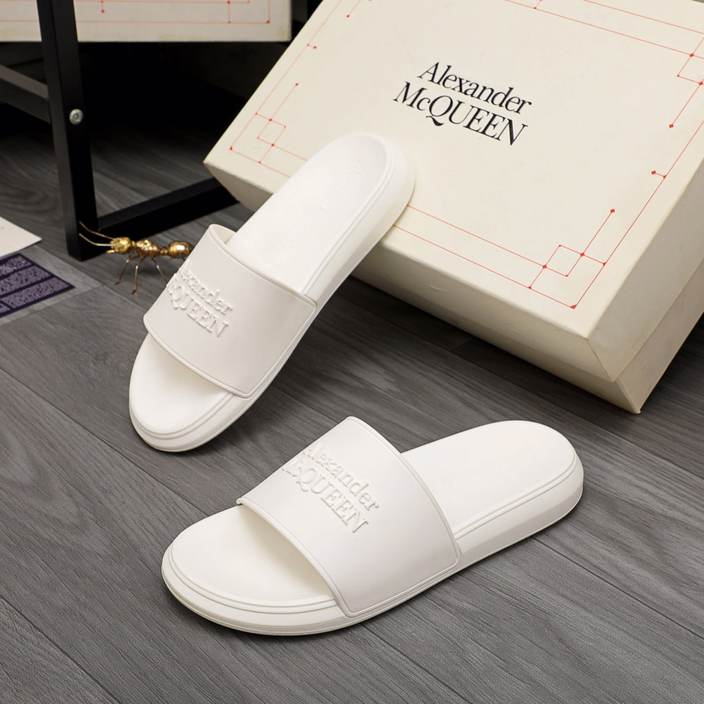 White slide sandals with wide strap and embossed logo detail