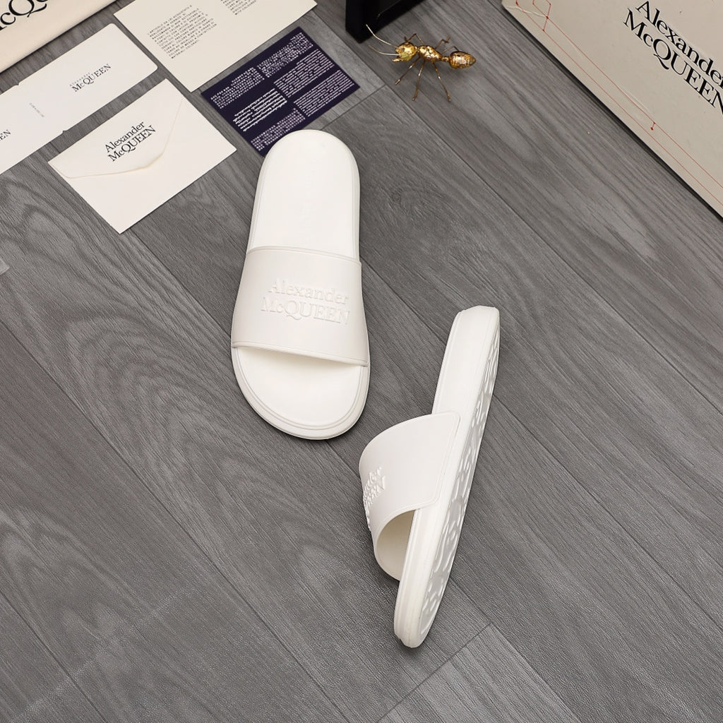 White slide sandals with embossed logo on the footbed