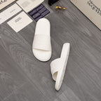 White slide sandals with embossed logo on the footbed