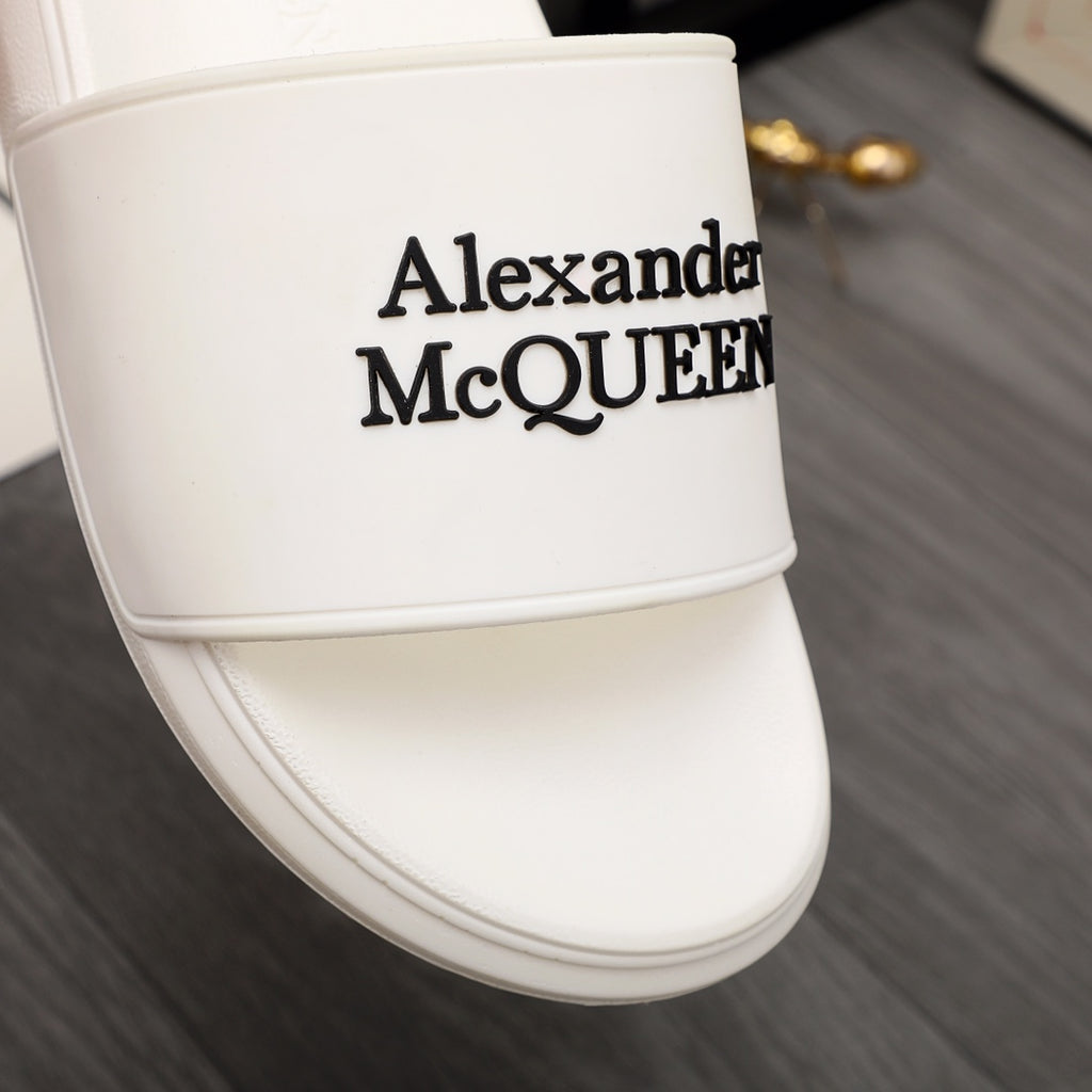 White slide sandal close-up of Alexander McQUEEN logo on strap