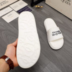 White rubber sole of slide sandal with matching logo strap pair