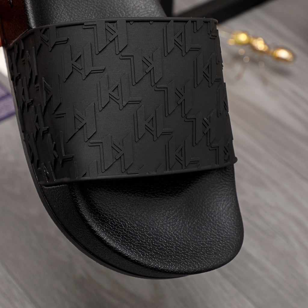 Black slide sandal with geometric embossed strap over smooth leather-like footbed