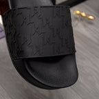 Black slide sandal with geometric embossed strap over smooth leather-like footbed