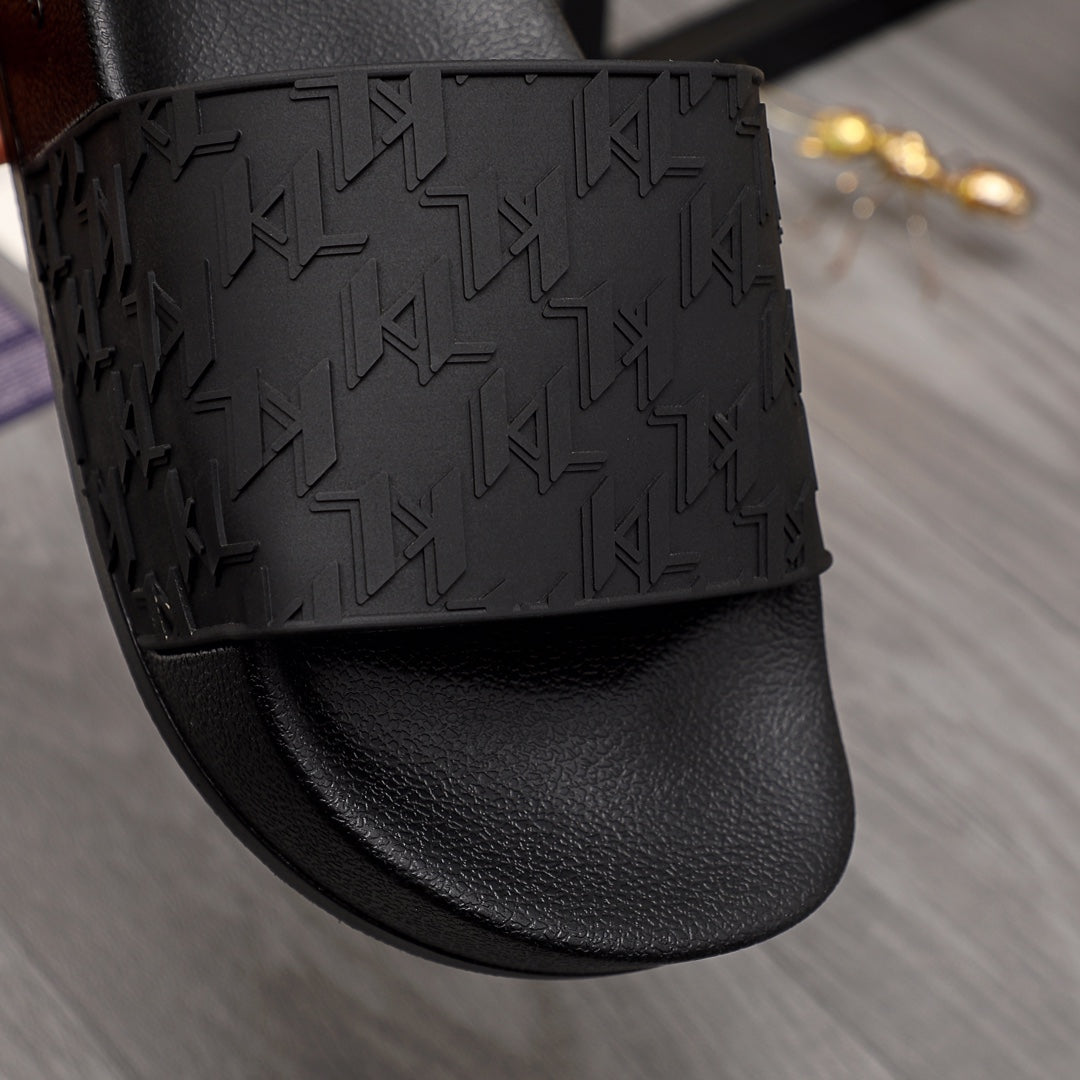 Black slide sandal with geometric embossed strap over smooth leather-like footbed
