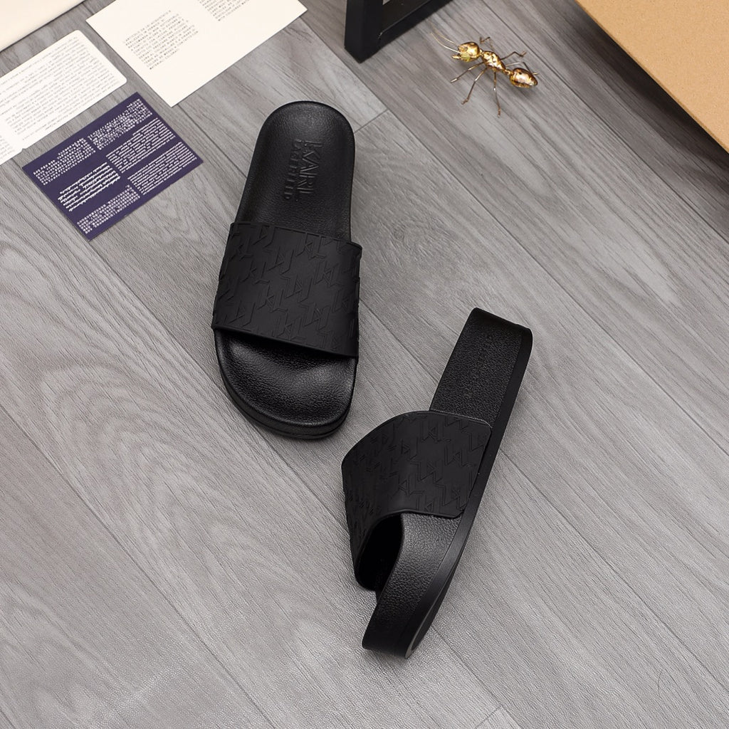 Black slide sandals with wide strap and textured footbed finish