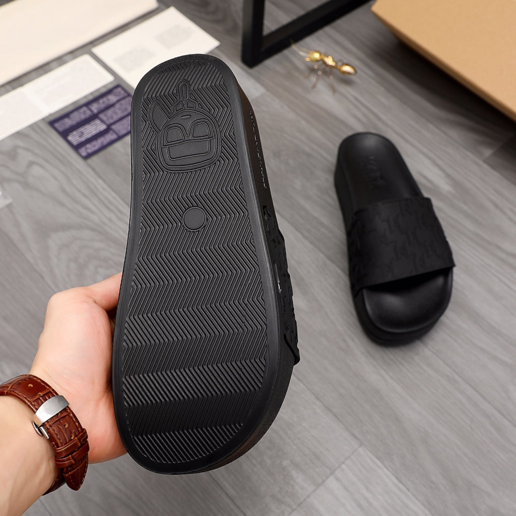 Black slide sandal outsole with tread pattern and smooth banded edge