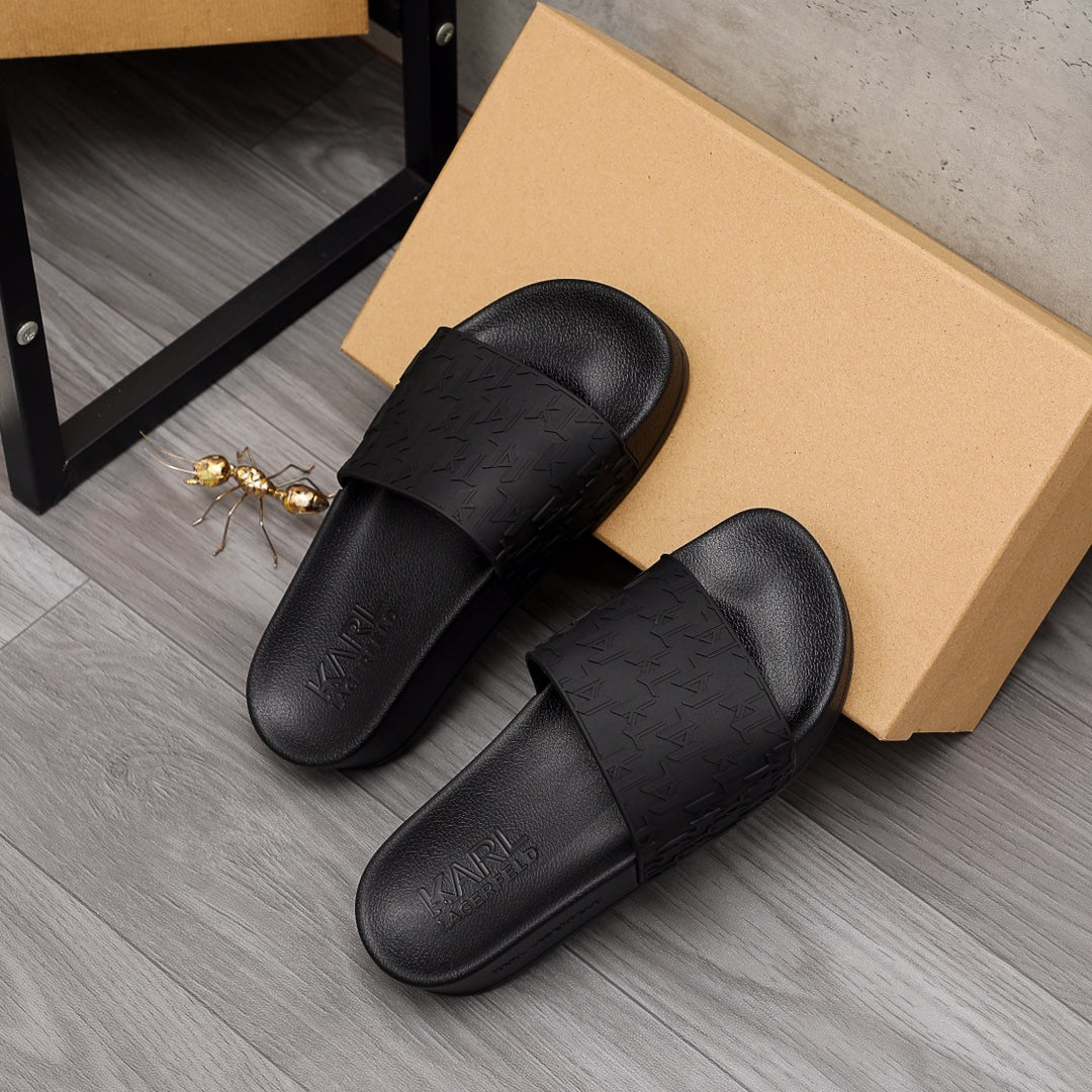 Black Alexander McQueen slide sandals with embossed strap pattern and padded footbed