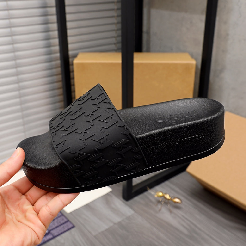 Black slide sandal with textured patterned strap and curved platform sole