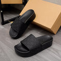 Black Alexander McQueen slide sandal with embossed logo strap and cushioned sole
