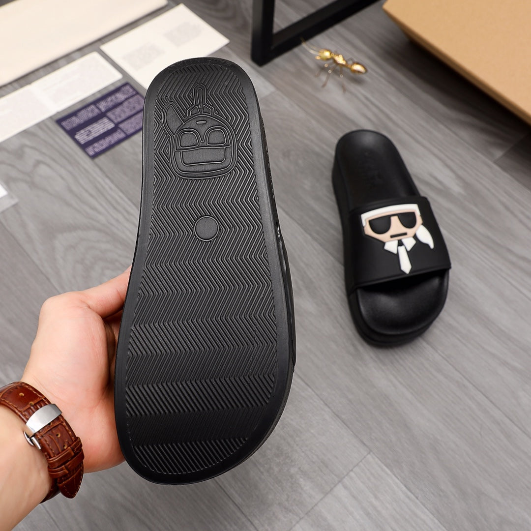 Black slide sandal outsole with textured tread and embossed logo, side view