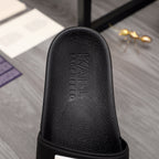 Black slide sandal footbed with embossed Alexander McQueen lettering