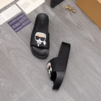 Black slide sandals, side view and toe view, with white character logo patch