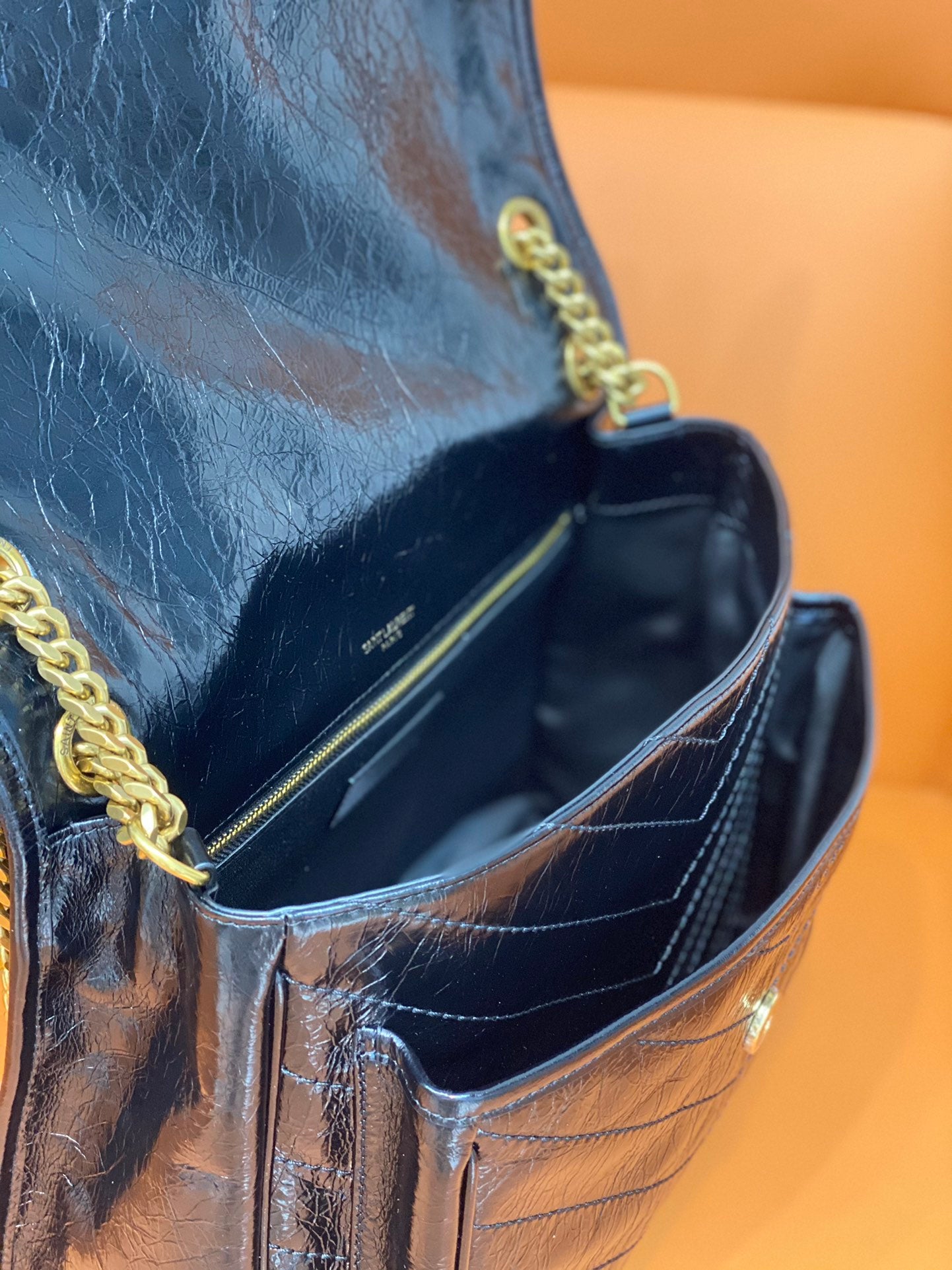 YSL Saint Laurent bag interior view, dark blue lining with gold chain trim
