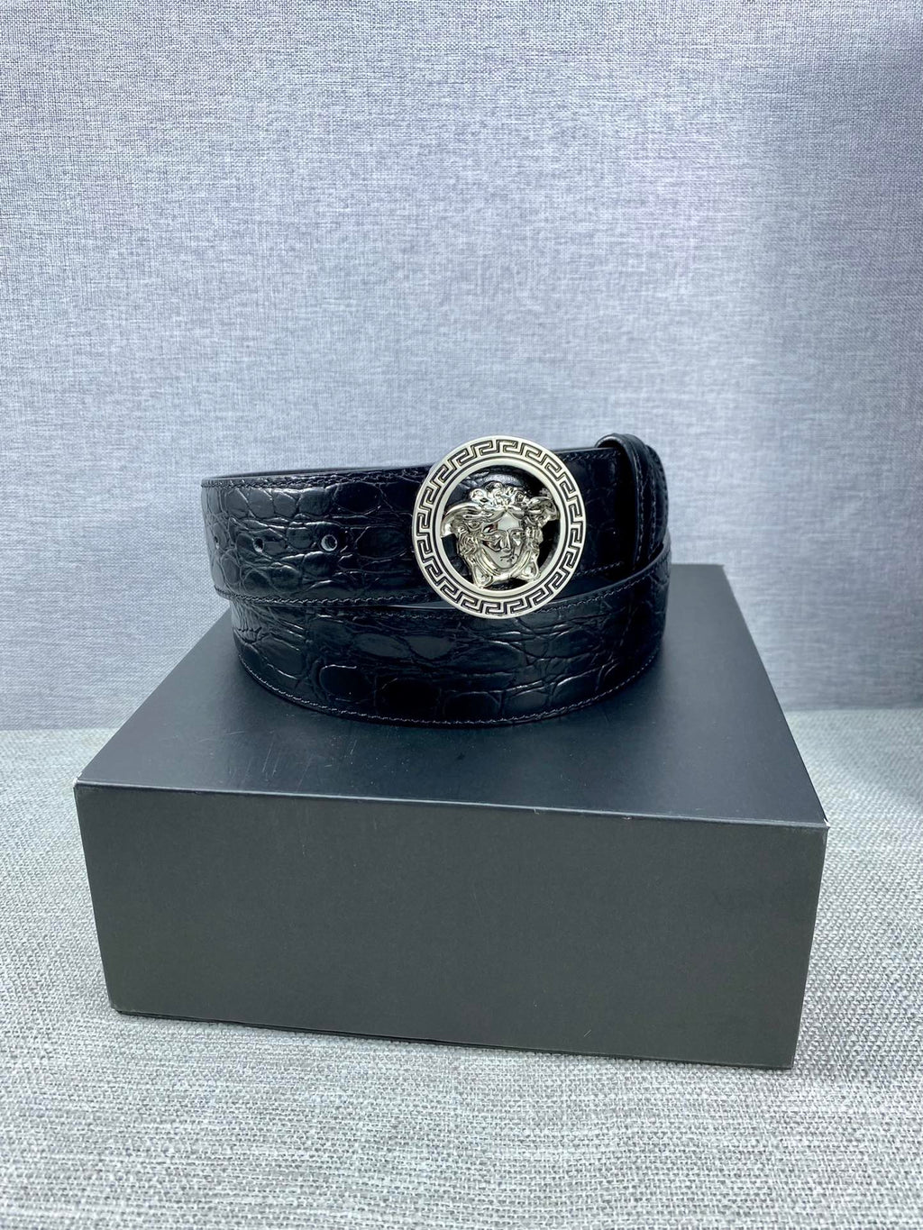 Black embossed leather belt with round Versace medallion buckle and wide strap