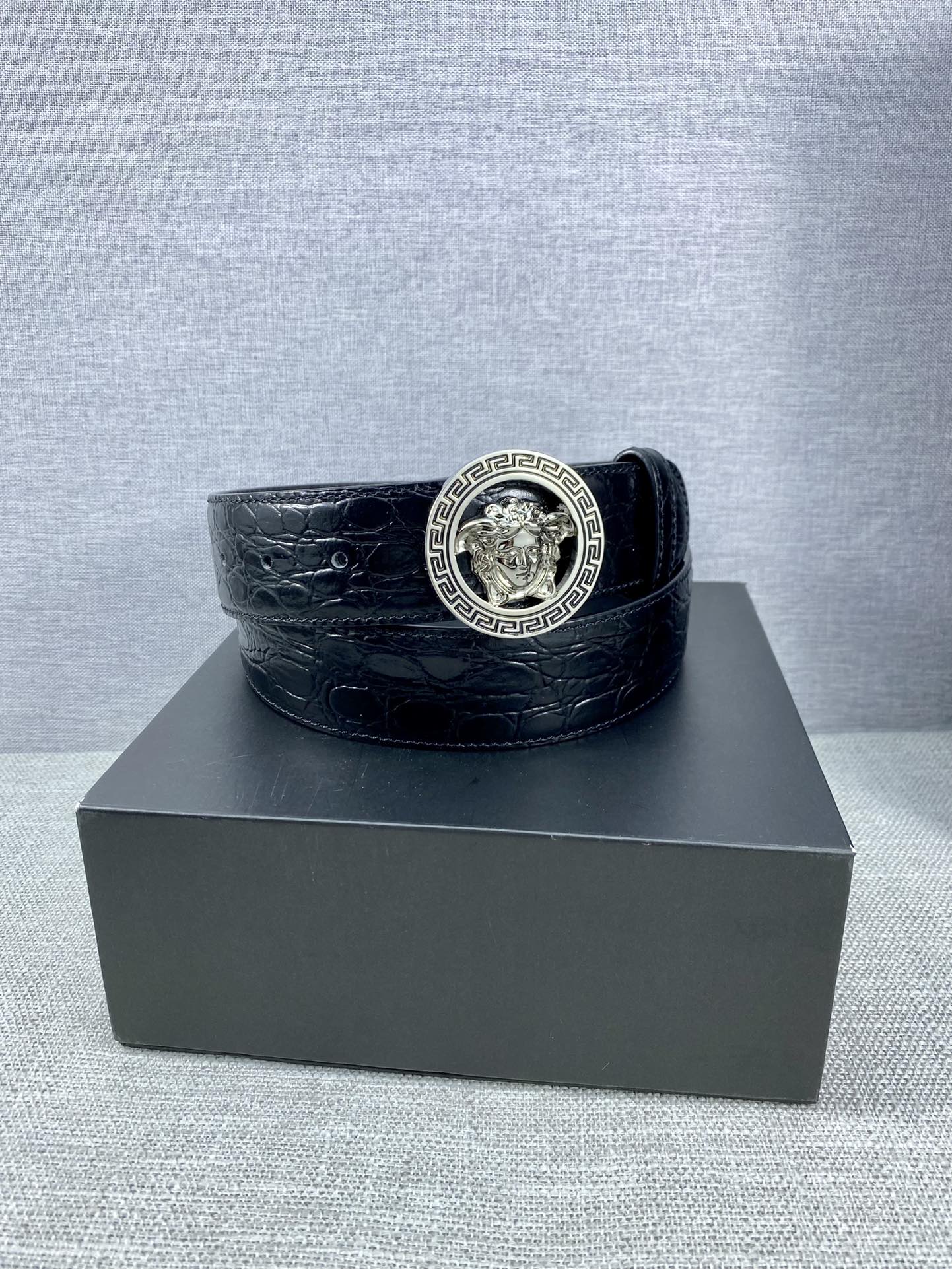 Black embossed leather belt with round Versace medallion buckle and wide strap
