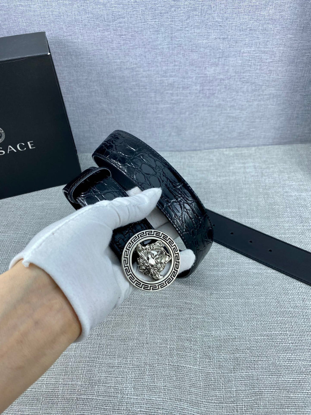 Black embossed leather belt with silver-tone Versace medallion buckle and strap slot