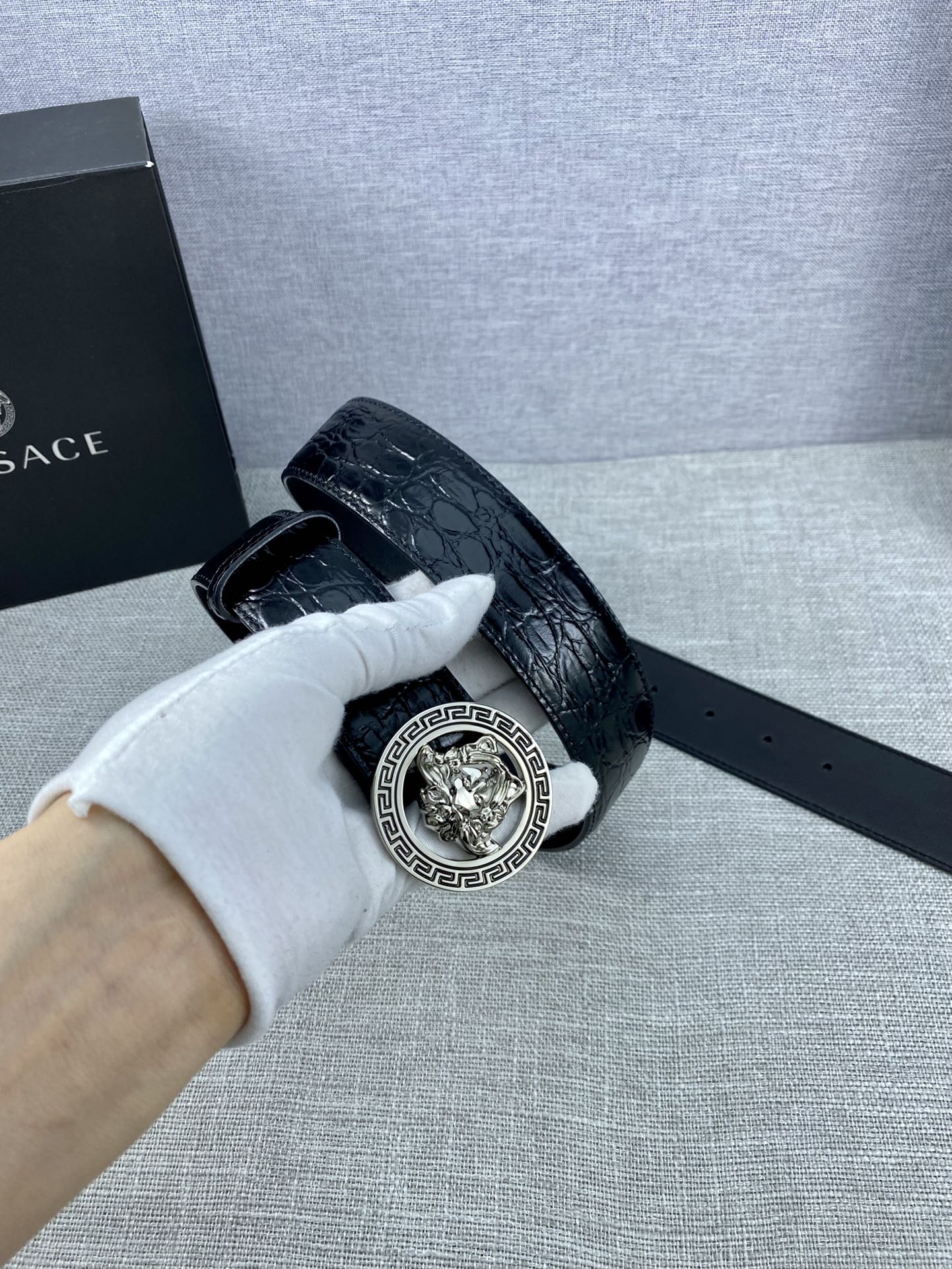 Black embossed leather belt with silver-tone Versace medallion buckle and strap slot