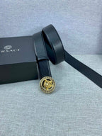 Black leather belt with gold Medusa buckle and two strap loops in view.