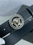 Black leather belt with embossed texture and gold Medusa round buckle clasp.