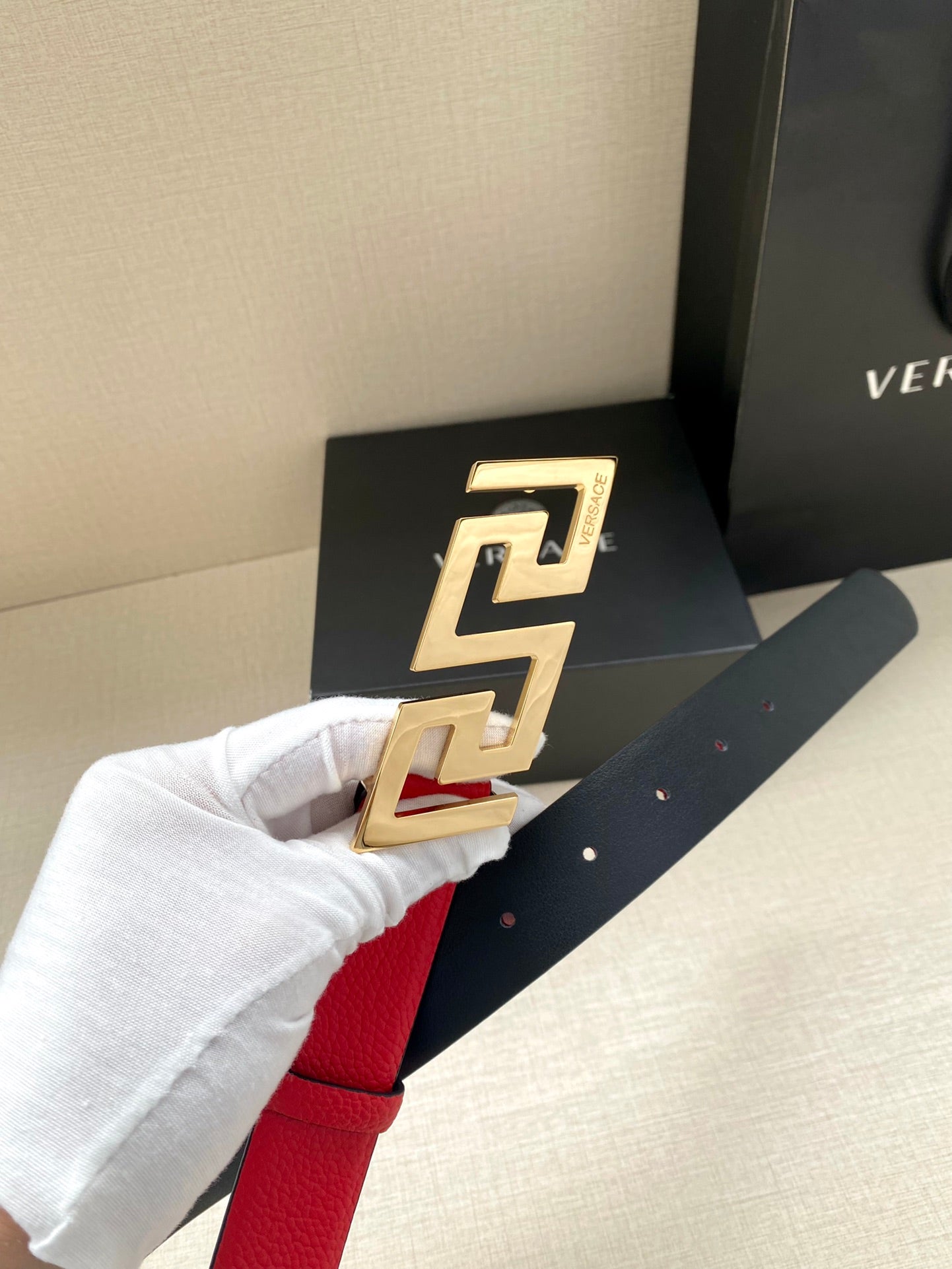 Versace red belt held up with gold-tone FF buckle