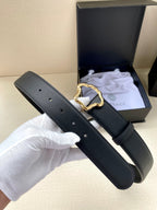 Black leather belt with silver-toned ornate buckle, end with holes shown
