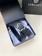Black leather belt with silver-toned ornate buckle, belt loop and holes visible