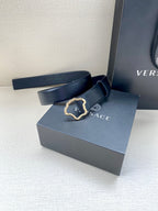Dark blue leather belt with ornate Medusa-shaped buckle and stitched strap