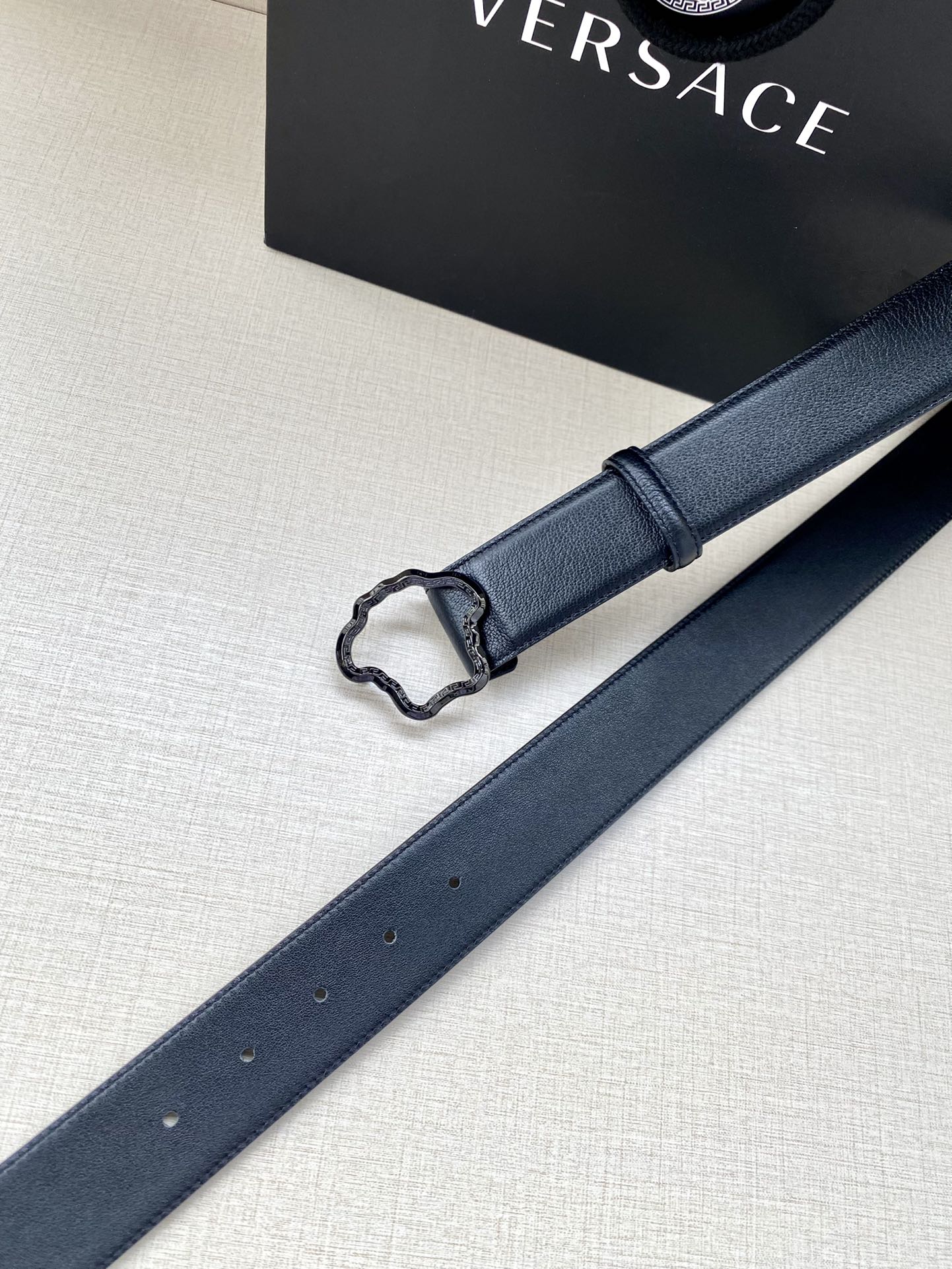 Navy leather belt strap with silver-tone buckle frame and punched holes