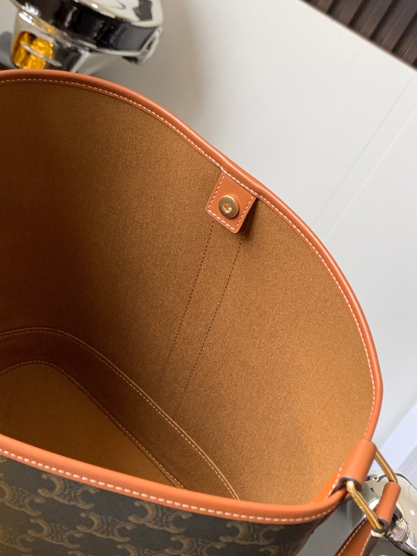 Celine bag interior with brown lining, stitched seams, and leather top edge