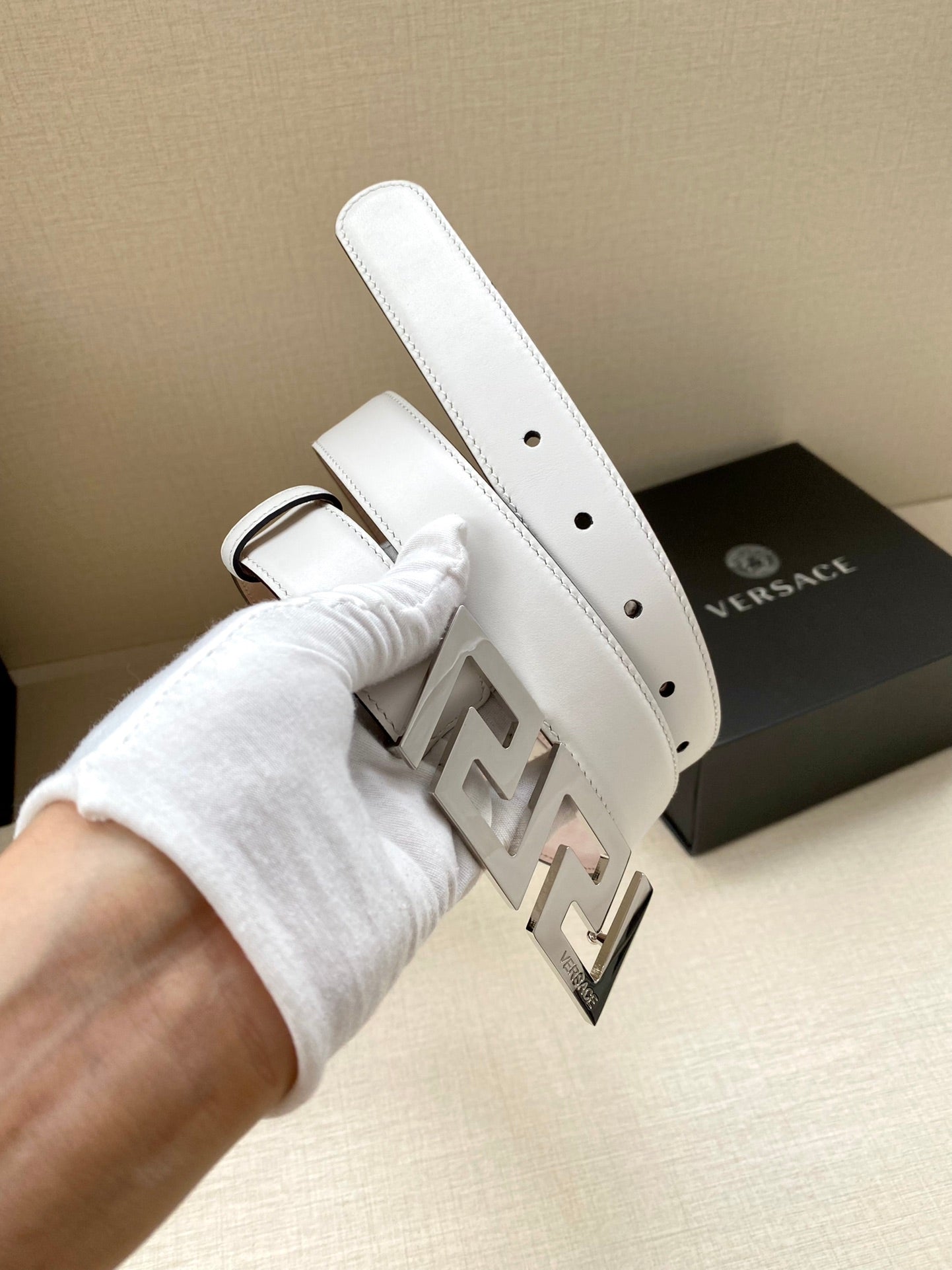 White leather belt end with punched holes and gold-tone FF buckle