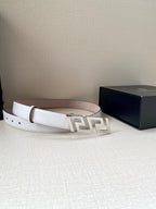 White leather belt with gold-tone FF buckle, belt looped on a surface